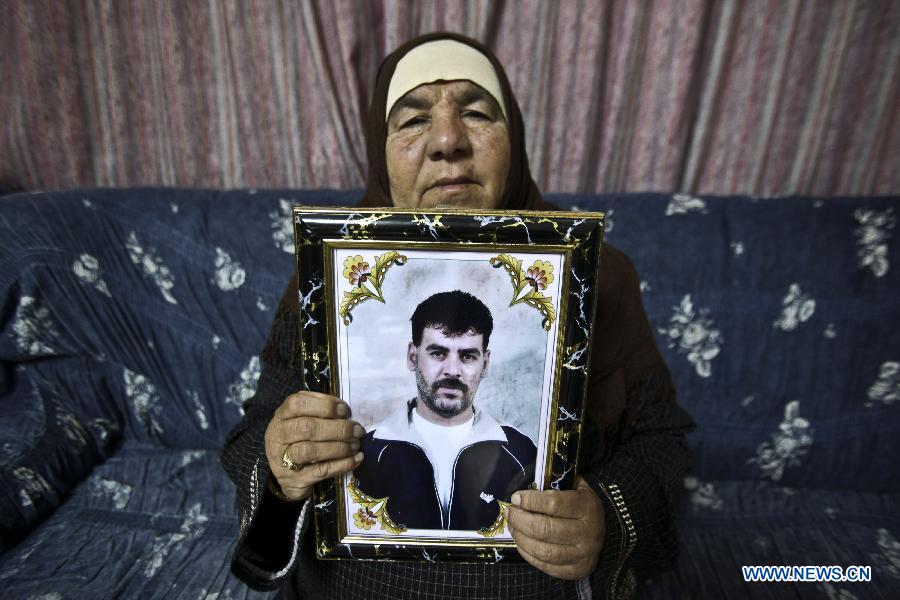 Mother of Palestinian prisoner Mahmoud Khasib poses with his picture at her house in the West Bank city of Ramallah, on Dec. 17, 2011. Mahmoud Khasib is one of 550 Palestinian prisoners who will be freed on Sunday from Israeli jails, in the second phase of a deal reached with the Islamic Hamas movement in October to free Israeli soldier Gilad Shalit.