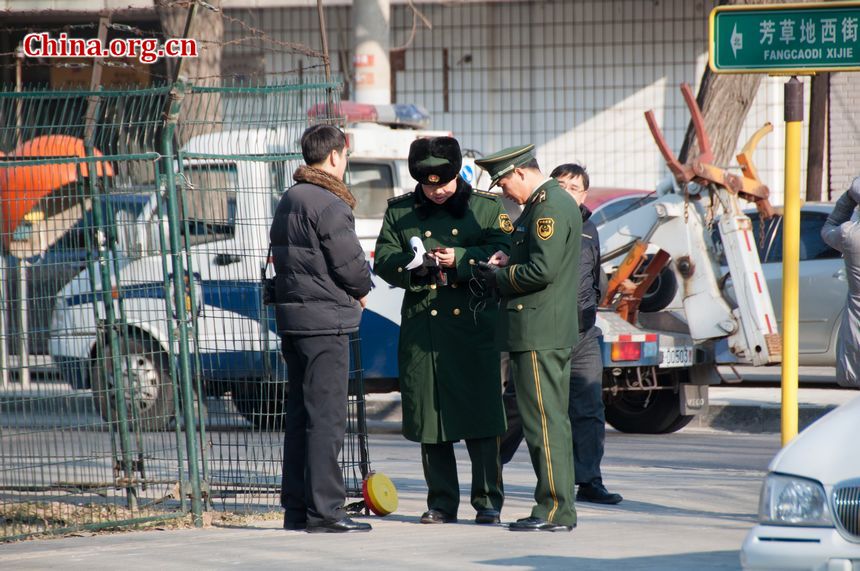 Armed police check a foreign pedestrian's ID as he walks past the Embassy of the Democratic People's Republic of Korea on Monday, December 19, 2001, following the news that Kim Jong Il, DPRK's top leader has died. [Maverick Chen / China.org.cn]