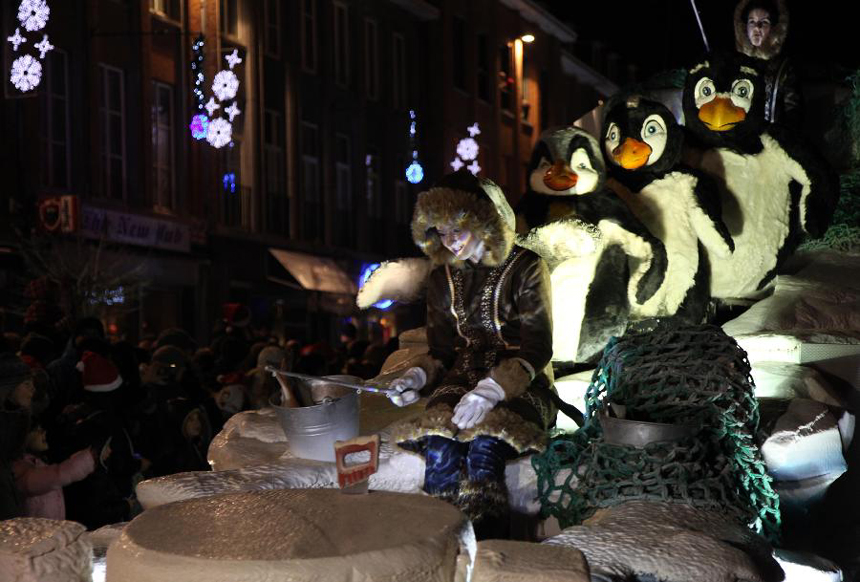 People dressed as penguins take part in the Christmas float parade held in Nivelles, Belgium, Dec. 17, 2011. About 14 floats offered performance and candies to local residents and tourists Saturday night at the Christmas float parade in Nivelles.