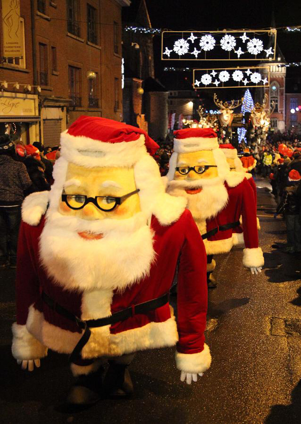 People dressed as Santa Claus take part in the Christmas float parade held in Nivelles, Belgium, Dec. 17, 2011. About 14 floats offered performance and candies to local residents and tourists Saturday night at the Christmas float parade in Nivelles. 