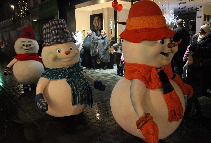 People dressed as snowmen take part in the Christmas float parade held in Nivelles, Belgium, Dec. 17, 2011. About 14 floats offered performance and candies to local residents and tourists Saturday night at the Christmas float parade in Nivelles. 