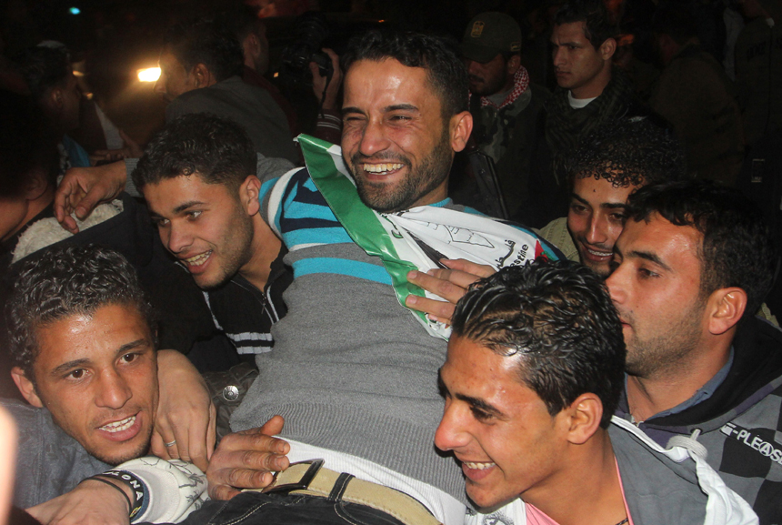 A freed Palestinian prisoner is greeted by relatives in Rafah border crossing in southern Gaza Strip on Dec. 18, 2011. Israel freed 550 Palestinian prisoners on Sunday evening in the second phase of a prisoner swap deal, while Hamas movement announced the Palestinian-Israeli agreement reached in October had been finalized.