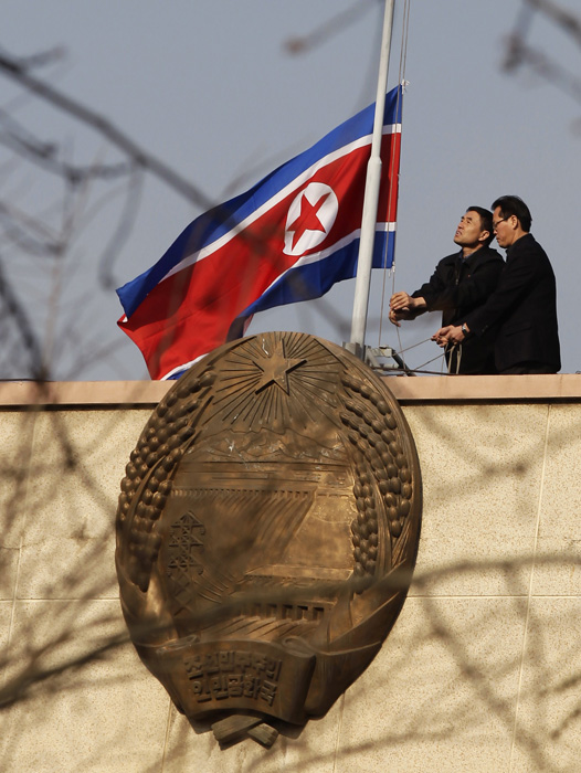 Staff members of the Embassy of the Democratic People's Republic of Korea in Beijing lower their national flag at half-mast to mourn the death of Kim Jong Il, Monday, Dec. 19, 2011. [Photo from news.ifeng.com]