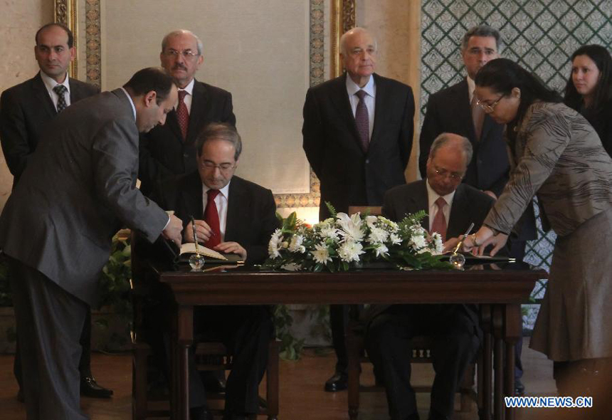 Arab League (AL) Deputy Secretary General Ahmed Ben Helli (2nd R, Front) signs the AL observer deal with Syrian Deputy Foreign Minister Faisal Mekdad (2nd L, Front) at the AL's Headquarters in Cairo, Egypt, on Dec. 19, 2011
