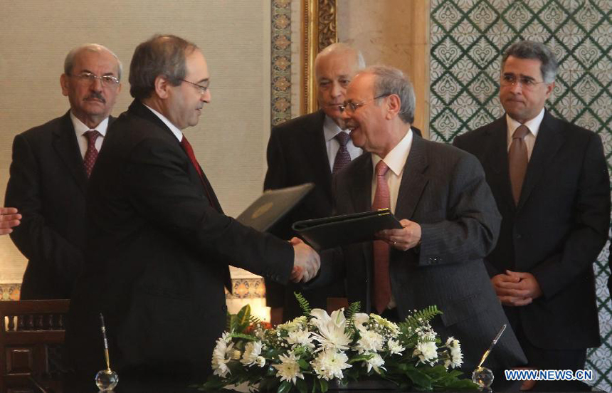 Arab League (AL) Deputy Secretary General Ahmed Ben Helli (R, Front) shakes hands with Syrian Deputy Foreign Minister Faisal Mekdad (L, Front) after signing the AL observer deal at the AL's Headquarters in Cairo, Egypt, on Dec. 19, 2011