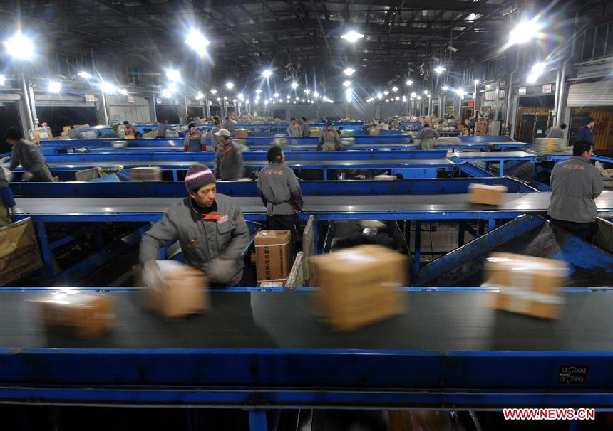 Laborers work in an express delivery company in Hangzhou, capital of east China's Zhejiang Province, Dec. 17, 2011. As the New Year draws near, a severe strain has been put upon China's express delivery companies because of the rising number of packages.