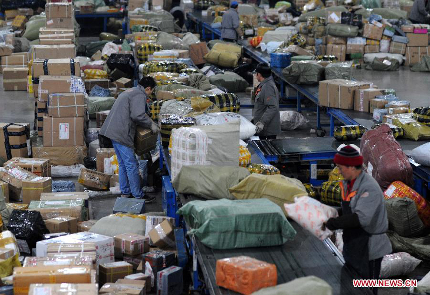 Laborers work in an express delivery company in Hangzhou, capital of east China's Zhejiang Province, Dec. 17, 2011. As the New Year draws near, a severe strain has been put upon China's express delivery companies because of the rising number of packages. 