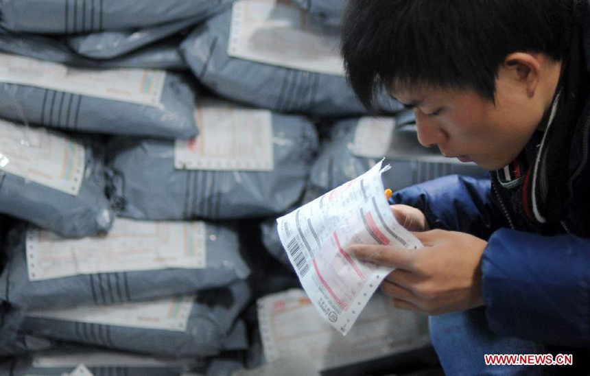 An online retailer fills in a table for express delivery in Hangzhou, capital of east China's Zhejiang Province, Dec. 17, 2011. As the New Year draws near, a severe strain has been put upon China's express delivery companies because of the rising number of packages.