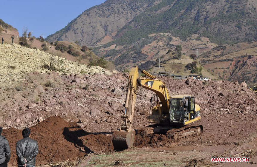 An excavator works at the spot of landslide in Yunlong County of the Dali Bai Autonomous Prefecture, southwest China's Yunnan Province, Dec. 18, 2011. The landslide, which occurred at 7:50 p.m. Saturday, has blocked the Bijiang River and formed a barrier lake, threatening hundreds of people. Authorities in Yunlong county are rushing to evacuate local residents and divert water from the river.