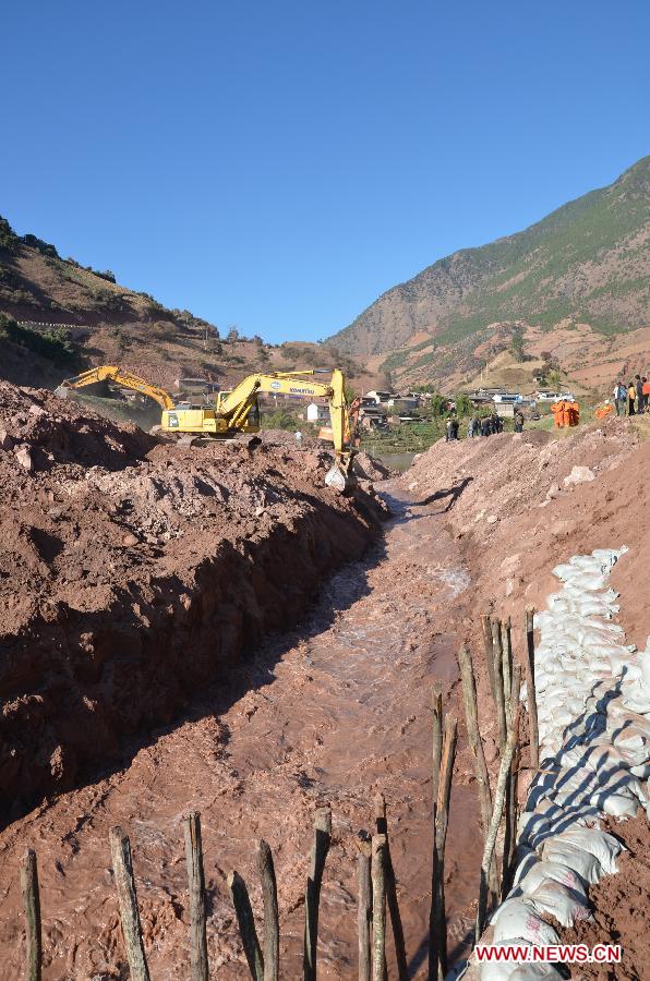 Water flows out of the barrier lake through spillway in Yunlong County of the Dali Bai Autonomous Prefecture, southwest China's Yunnan Province, Dec. 18, 2011. After a twenty hours effort, rescuers had successfully dug a spillway to divert the water from the barrier lake on Sunday afternoon. A landslide, which occurred at 7:50 p.m. Saturday, had blocked the Bijiang River and formed a barrier lake.