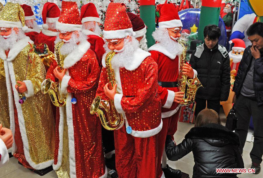 Businessmen look at the decorations for Christmas and the New Year at the International Trade City in Yiwu, east China's Zhejiang Province, Dec. 18, 2011.