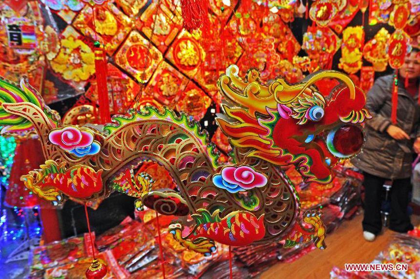 A shopkeeper wait for customers at a booth selling decorations for Christmas and the New Year at the International Trade City in Yiwu, east China's Zhejiang Province, Dec. 18, 2011. 