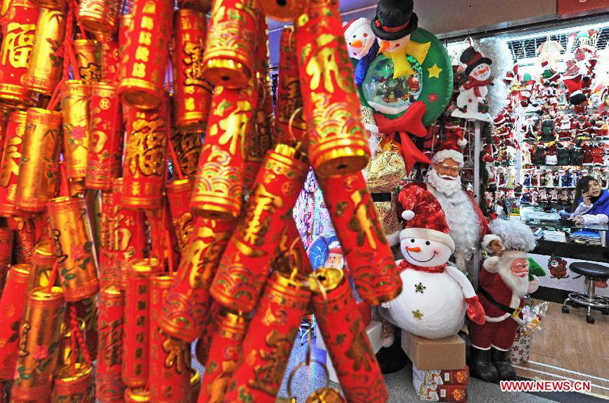 A shopkeeper makes a phone call at a booth selling decorations for Christmas at the International Trade City in Yiwu, east China's Zhejiang Province, Dec. 18