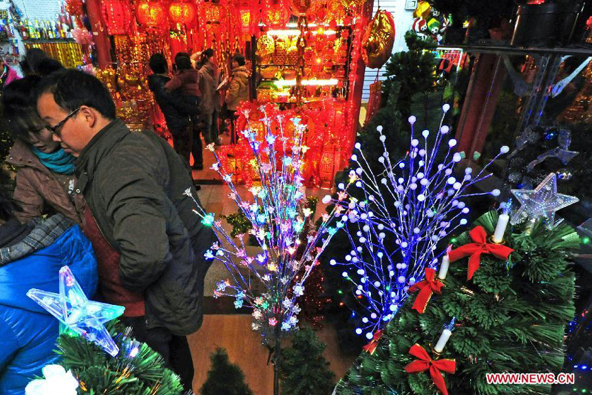 Businessmen look at decorations for Christmas and the New Year at the International Trade City in Yiwu, east China's Zhejiang Province, Dec. 18, 2011.