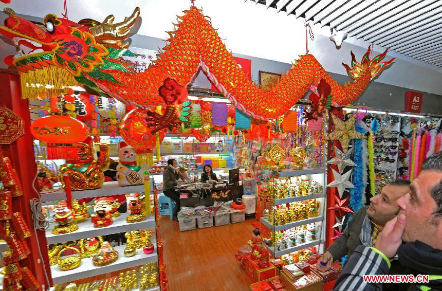 Businessmen look at decorations for the New Year at the International Trade City in Yiwu, east China's Zhejiang Province, Dec. 18, 2011.