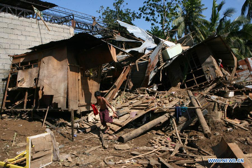 A boy runs from his home that was swept to the roadside after tropical storm Washi triggered flash floods in Cagayan De Oro, the Philippines, on Dec. 19, 2011. The death toll from tropical storm Washi has risen to 632, and hundreds more still missing. 