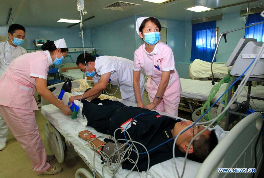 Medical members attend an 'injured' soldier in the ICU ward on Chinese Navy hospital ship 'Peace Ark' during a drill in the Pacific on Dec. 19, 2011. The hospital ship 'Peace Ark' is on its way home after conducted humanitarian voyage 'Mission Harmony-2011' in the Latin American nations. 