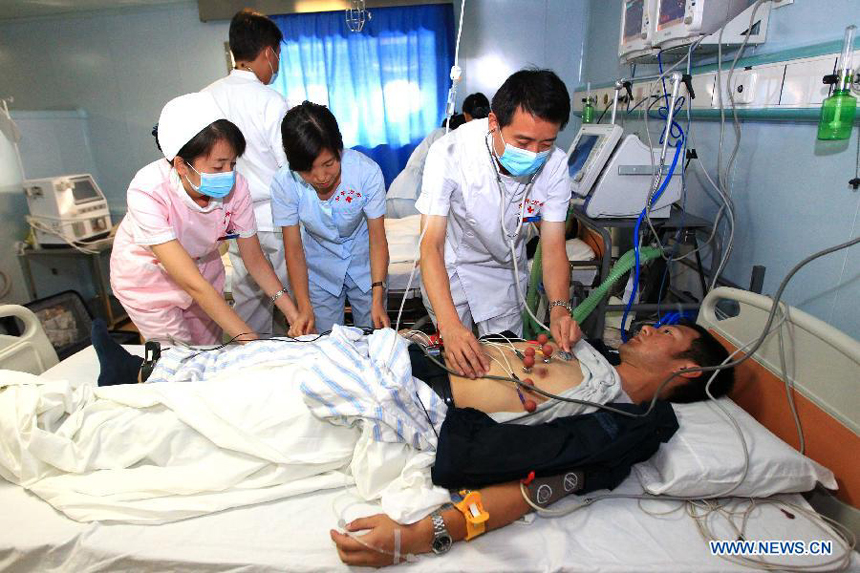 Medical members attend an 'injured' soldier in the ICU ward on Chinese Navy hospital ship 'Peace Ark' during a drill in the Pacific on Dec. 19, 2011. The hospital ship 'Peace Ark' is on its way home after conducted humanitarian voyage 'Mission Harmony-2011' in the Latin American nations.