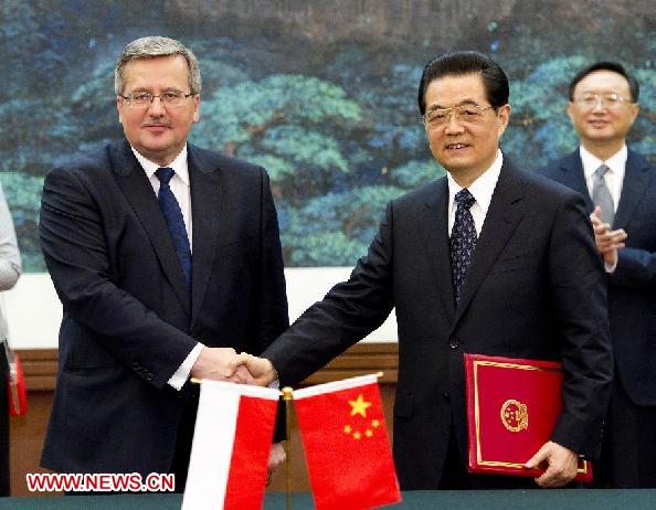 Chinese President Hu Jintao (R, front) shakes hands with visiting Polish President Bronislaw Komorowski after they signed a joint statement extending bilateral relations to a level of strategic partnership in Beijing, capital of China, Dec. 20, 2011. [Huang Jingwen/Xinhua] 