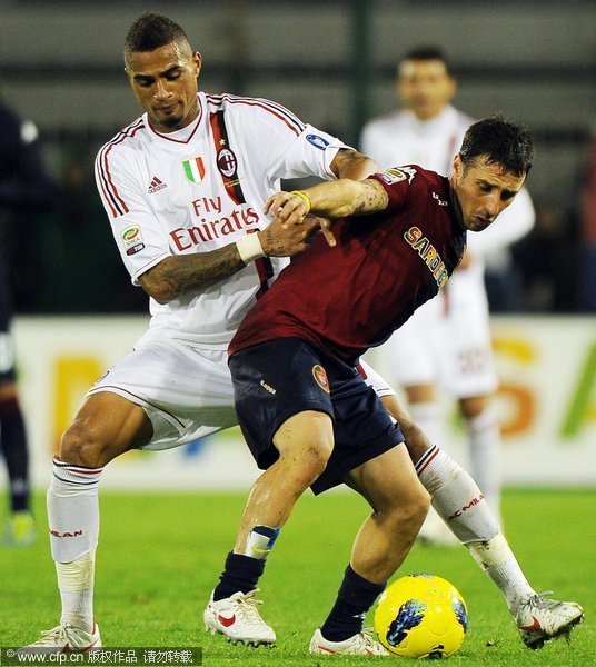 Cagliari's Andrea Cossu (R) vies for the ball with AC Milan's Ghanaian midfielder Kevin-Prince Boateng (L) during the Italian Serie A soccer match between Cagliari Calcio and AC Milan at the Sant'Elia stadium in Cagliari, Italy, 20 December 2011.