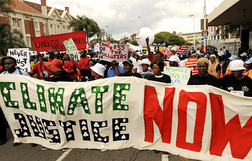 ACTION NOW: Members of non-governmental organizations hold banners in a demonstration in Durban on December 3, 2011, calling for the world to take action against climate change [By Li Qihua]