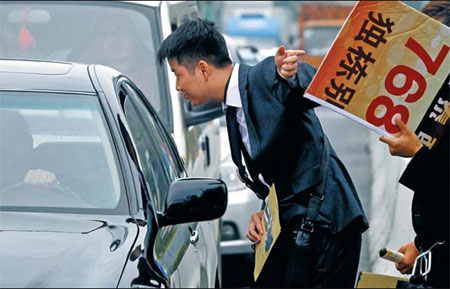 A real estate agent tries to interest a driver in a villa in Shanghai on Nov 5. Cash-strapped developers and real estate agents are desperate to seek buyers amid a sluggish market stemming from the government's tightening policies. [China Daily]