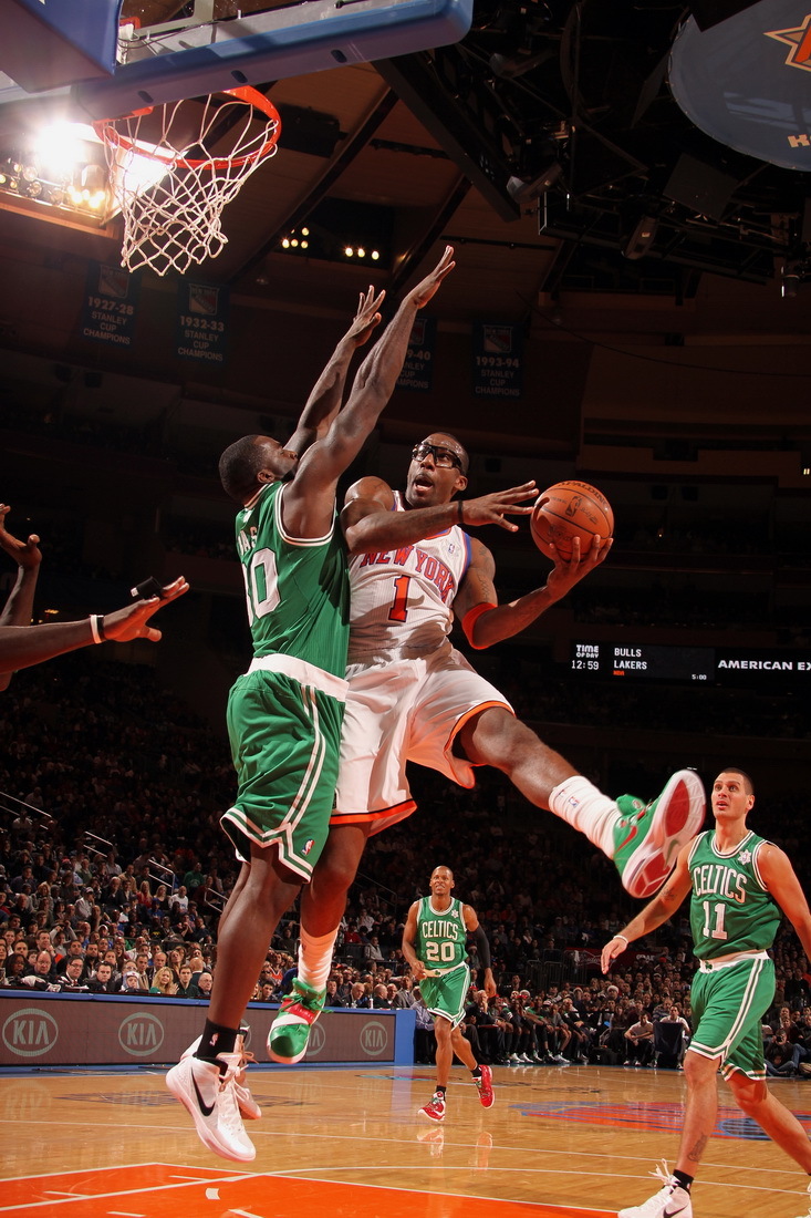 New York Knicks power forward Amare Stoudemire tries to shoot around Boston Celtics power forward Brandon Bass (left) in the first half of their NBA basketball game at Madison Square Garden in New York, Sunday, Dec. 25, 2011. [Source:Sina.com]