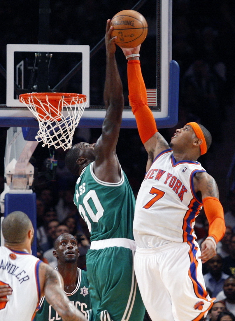 Carmelo Anthony of New York Knicks was blocked by Brandon Bass of Boston Celtics in the first half of their NBA basketball game at Madison Square Garden in New York, Sunday, Dec. 25, 2011. [Source:Sina.com]