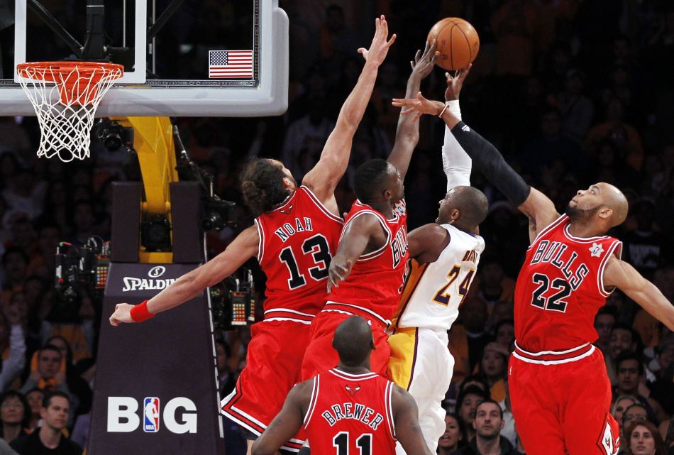 Los Angeles Lakers guard Kobe Bryant puts up a shot against Chicago Bulls center Joakim Noah, forward Luol Deng, guard Ronnie Brewer and forward Taj Gibson as time expires in the second half of their NBA basketball game, Sunday, Dec. 25, 2011, in Los Angeles. [Source: Sina.com]