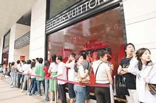 Chinese tourists queue outside a boutiquet of Louis Vuitton [File photo] 