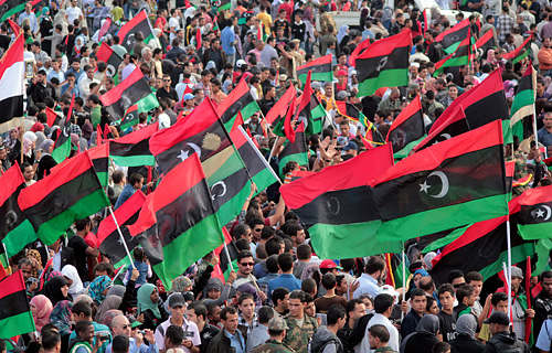 Libyan people wave their new national flag to celebrate the fall of the Muammar Gaddafi regime in Benghazi on October 23 [XINHUA/AFP] 