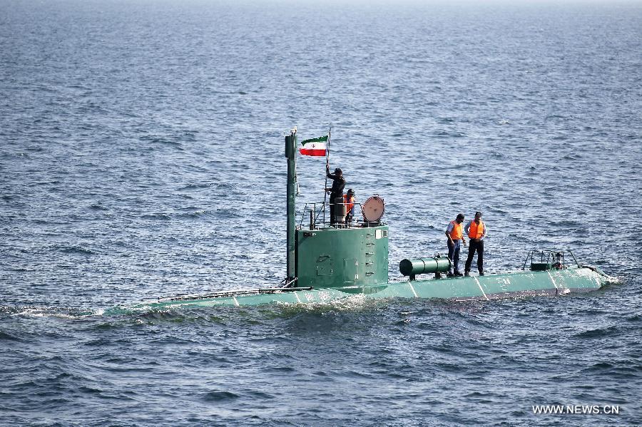 A soldier erects a flag of Iran on a submarine during Iranian naval maneuvers dubbed Velayat 90 on the Sea of Oman, Iran, Dec. 27, 2011. [Ali Mohammadi/Xinhua]