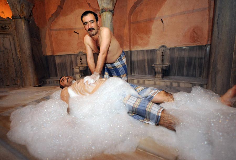 A man receives a bubble massage in a Turkish hamam named "Cemberlitas&...