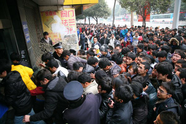 Many students rush a train ticket sales agent in an attempt to buy a ticket home for the winter break in Nanjing city, capital of East China's Jiangsu province on Dec 28, 2011, the day the rail authority started selling student tickets for the Spring Festival travel period.[Photo/CFP]