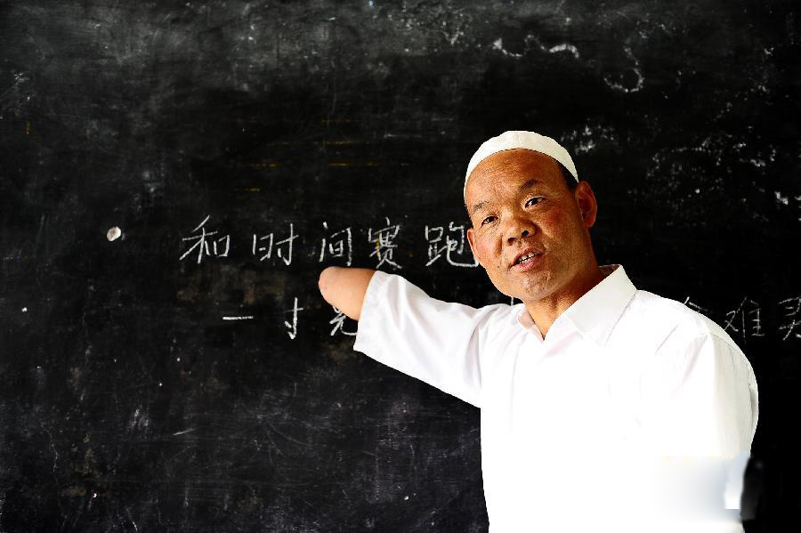 Ma Fuxing, a primary school teacher who lost both his forearms, teaches his class Chinese in Ma'er Village in Xining's Huangzhong County, Qinghai Province. Ma learned to hold a chalk with his elbows and write and draw beautifully.