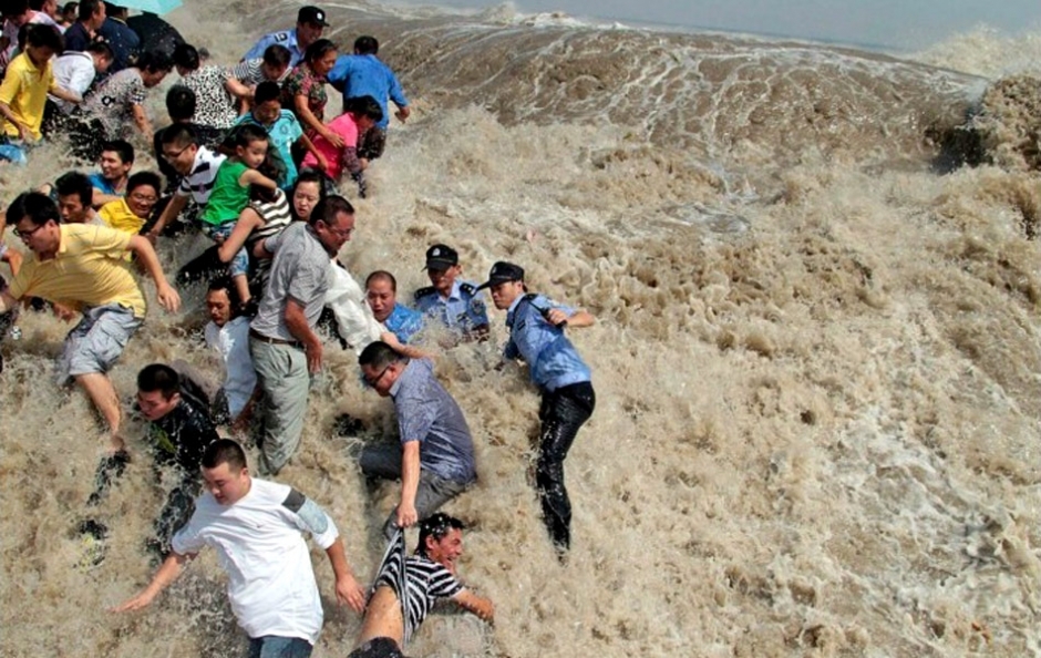 Tide watchers flee as the bore of the Qiantang River raises huge waves on August 31, 2011, at Laoyancang, one of the best tide-viewing spots in the city of Haining in Zhejiang Province. More than 20 people were injured as the tide washed about 100 visitors down the embankment with the splash.