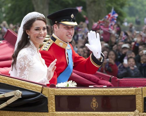 Their Royal Highnesses Prince William, Duke of Cambridge and Catherine, Duchess of Cambridge make the journey by carriage procession to Buckingham Palace past crowds of spectators following their marriage at Westminster Abbey on April 29, 2011 in London. [Photo by Tang Shi]