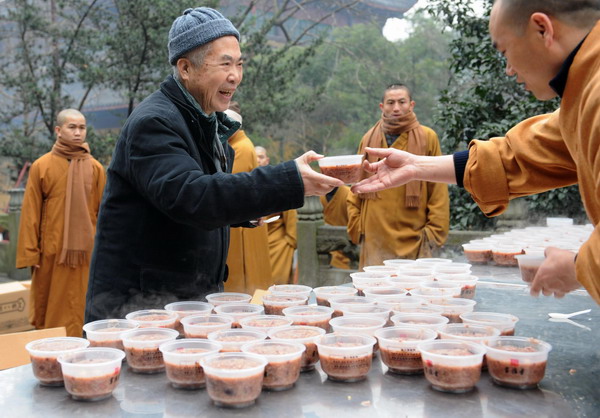 An old man receives free Laba rice porridge at Lingyin Temple in Hangzhou, East China's Zhejiang province, Jan 1, 2012.