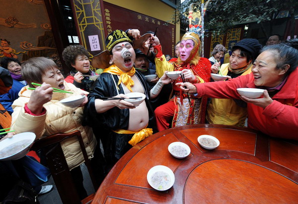 Two actors playing characters in Chin's classic novel, Journey to the West, enjoy Laba rice porridge with the crowds at a temple in Nanjing, East China's Jiangsu province, Jan 1, 2012. 