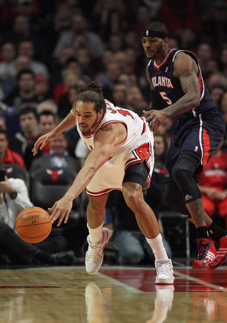 Joakim Noah of the Chicago Bulls chases down the ball under pressure from Josh Smith of the Atlanta Hawks at the United Center on January 3, 2012 in Chicago, Illinois.