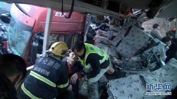 Thirteen people died and 41 others were injured, including nine seriously, when a heavy-duty truck collided with a coach in Hunan Province Tuesday morning. In the picture rescuers at the site have to dismantle the mangled bus in order to extricate the passengers inside. 