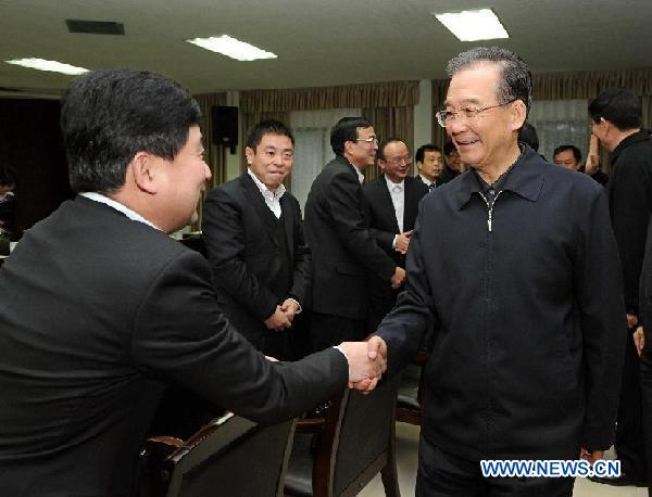 Chinese Premier Wen Jiabao (R, front) shakes hands with one of the principals of Hunan Jiangbin Machinery (group) Co., Ltd. in Xiangtan, central China's Hunan Province, Jan. 1, 2012, during a visit to the company. Wen made an inspection tour in Hunan's Xiangtan City and Zhuzhou City on Jan. 1 and 2. 