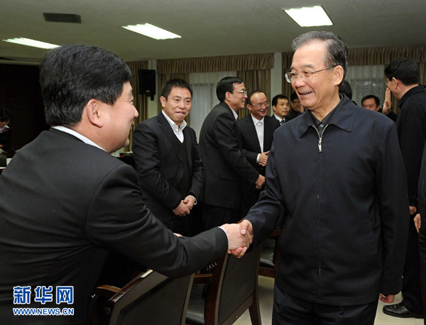 Premier Wen Jiabao (R, front) shakes hands with one of the principals of Hunan Jiangbin Machinery (group) Co., Ltd. in Xiangtan, Hunan Province, Jan. 1, 2012, during a visit to the company. Wen made an inspection tour in Hunan's Xiangtan City and Zhuzhou City on Jan. 1 and 2.