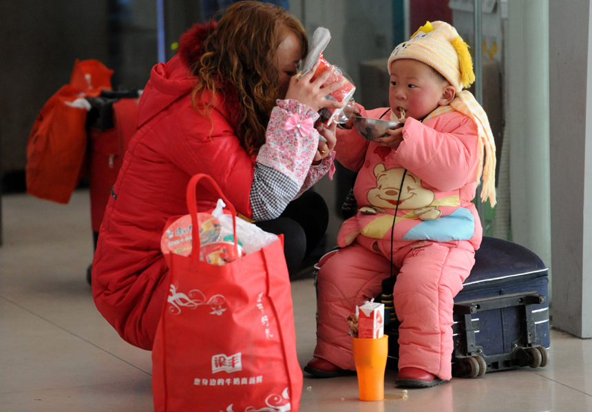 Spring Festival, or Chinese Lunar New Year, which this year falls on Jan. 23, is traditionally the time when millions of Chinese rush home for family reunions and celebrations. In this picture, mother and daughter share an impromptu snack in Nanjing, Jiangsu Province, on Jan. 3. [Xinhua photo] 