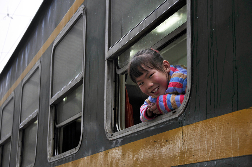 Spring Festival, or Chinese Lunar New Year, which this year falls on Jan. 23, is traditionally the time when millions of Chinese rush home for family reunions and celebrations. In this picture, a young girl is happy to be on board and ready to go in Nanjing, Jiangsu Province, on Jan. 3. [Xinhua photo] 