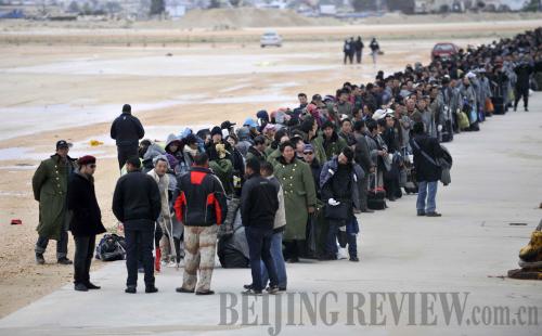 Chinese evacuees wait in line to board a chartered vessel on February 25, 2011 in Benghazi, a port city in northeast Libya. [Yu Yang] 