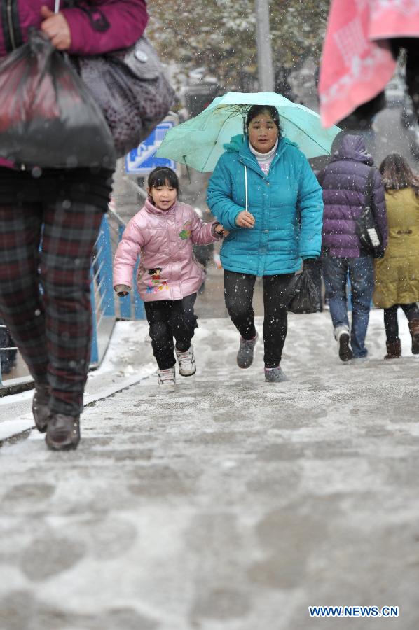 Pedestrians walk in snow in Guiyang, capital of southwest China's Guizhou Province, Jan. 4, 2012. 