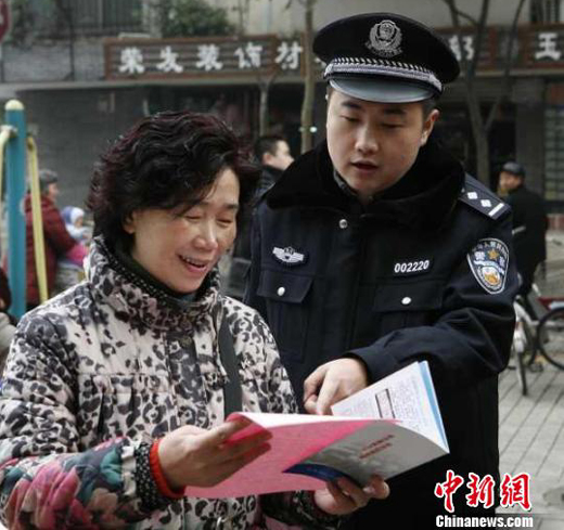 Police retrieved nearly 1.1 billion yuan raised through illegal fundraising during a crackdown campaign that lasted from Nov. 10 to Dec. 15, 2011. In the picture a policeman distributes publicity materials to local a local resident during the campaign in Chendu, Sichuan Province. 