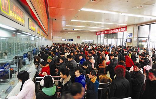 China's railways will carry 235 million passengers during the 40-day Spring Festival travel rush, up 6.1 percent year-on-year. In the picture, people are queuing for tickets at the Wuchang Railway Station, Hubei Province.