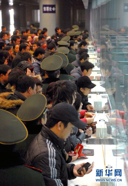 China's railways will carry 235 million passengers during the 40-day Spring Festival travel rush, up 6.1 percent year-on-year. In the picture, people are queuing for tickets at the Tianjin Railway Station. 